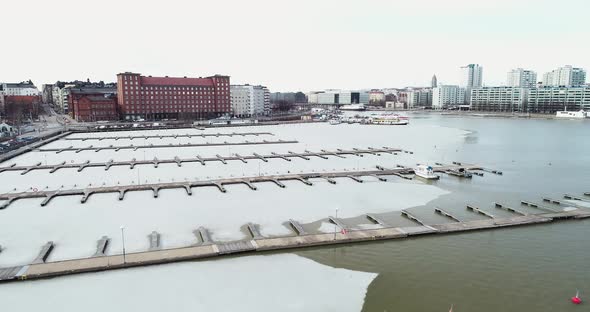 Aerial shot of some frozen docks in Helsinki, Finland. Shot moves forward at an average pace.