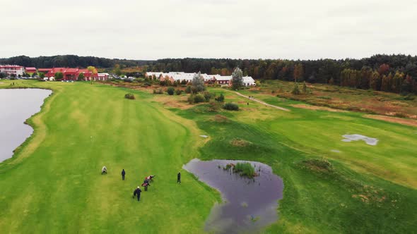 Aerial View of a Green Flat Surface Near a Rich Neighborhood and a Dense Forest with a Golf Course