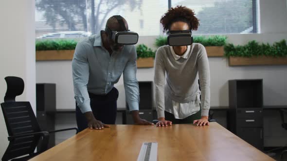 Diverse male and female business colleagues wearing vr headsets in office