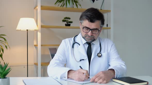 Senior Doctor Writing Information in Medical Registration Journal