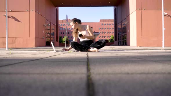 Slow motion shot of yoga teacher during video call in city