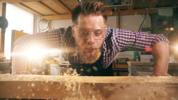 Male Woodworker Is Blowing the Shaving Away in Slow Motion