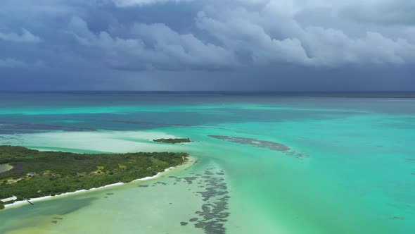 Flying towards the horizon line on the sea. Black clouds in the background, turquoise sea and differ