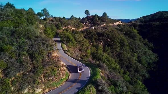 White Truck drives on Curvy Road in California Mountains, Drone Orbit