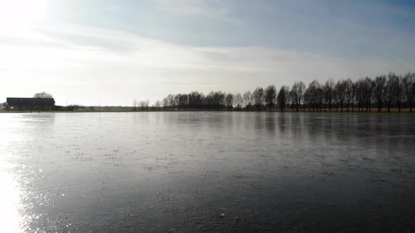 Frozen River With Sun Reflection During Sunset In Winter Near Sandelingen Park At Hendrik-Ido-Ambach