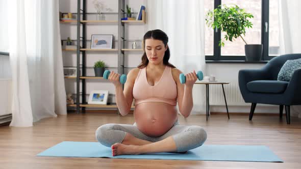 Pregnant Woman with Dumbbells Doing Sports at Home