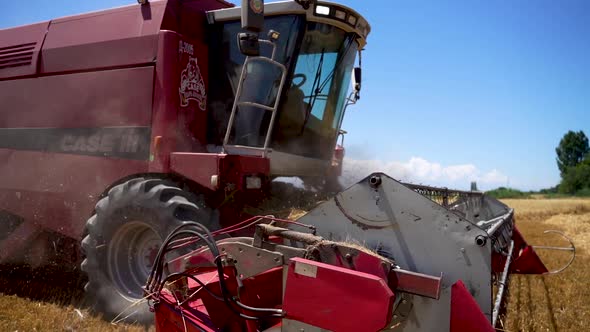 Slow motion combine harvester conveyer working on a field