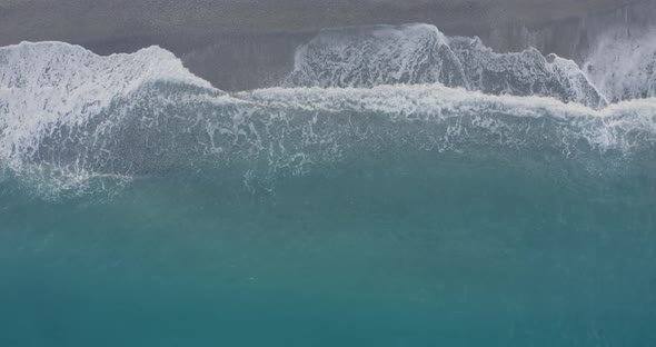 Aerial view waves breaking on the sandy beach