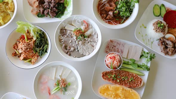 Male hand spinning Vietnamese noodle soup into visually appealing flat lay composition.