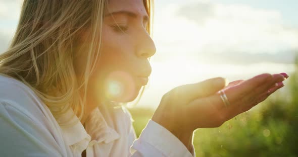 Young Woman Blowing Glitter