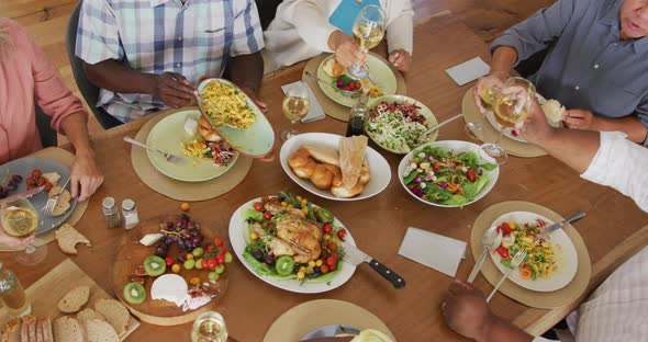 Happy senior diverse people having dinner at retirement home