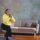 Athletic Woman in Yellow Hoodie Does Dynamic Lunges at Home - VideoHive Item for Sale