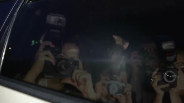 Celebrity Couple in Car Hiding With Hand From Magazine Photographers Cameras