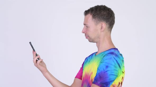 Profile View of Man with Tie-dye Shirt Getting Phone Taken
