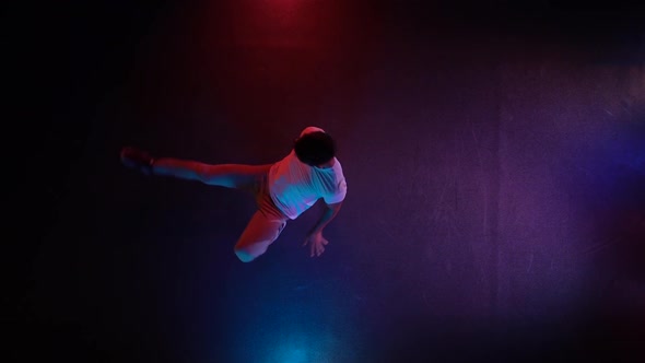 Young Man Dancing Breakdance in Black Studio. Top View. Slow Motion.