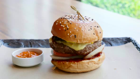 Burger with Beef Cutlet with Melted Cheese Onion Tomato Sauce on Black Slate