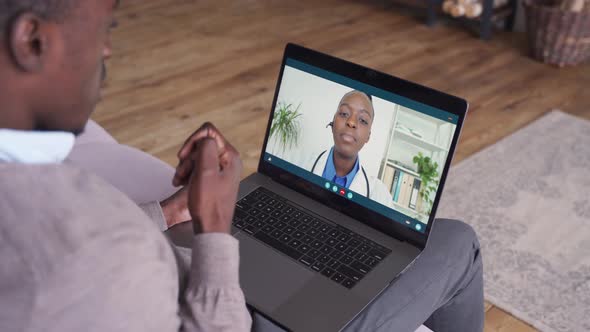 African American Man Video Calling Friend on Laptop at Home