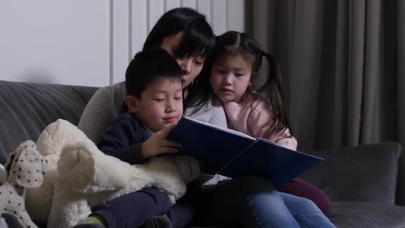 Chinese Mom Reading Interesting Book To Kids