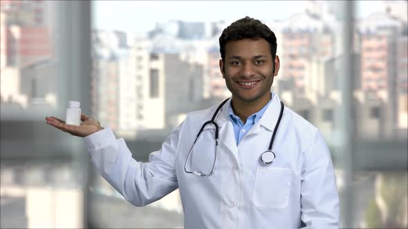 Smiling Indian Doctor Advertising Bottle of Medicine