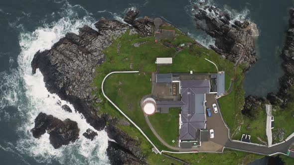 Top down aerial drone view of solitary lighthouse overlooking the North Atlantic Ocean