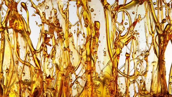 Super Slow Motion Shot of Splashing Golden Oil on White Background at 1000Fps