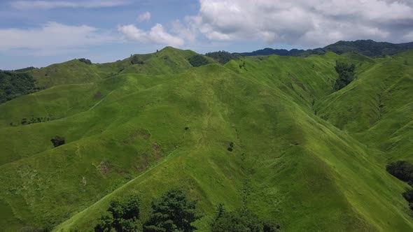 Flight Over a Green Grassy Rocky Hills