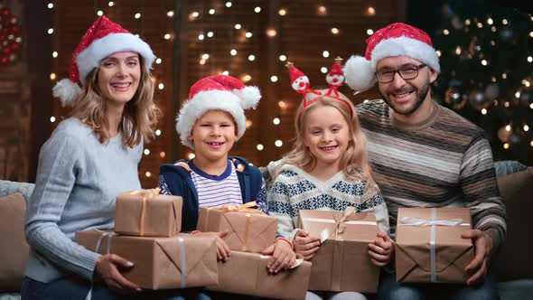 Family Wearing Christmas Horns and Santa Claus Hats Posing Together