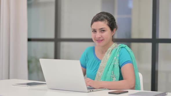 Indian Woman Showing Thumbs Up Sign While Using Laptop in Office