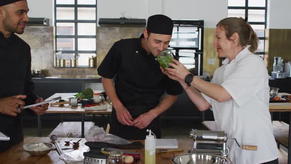 Caucasian female chef teaching diverse group