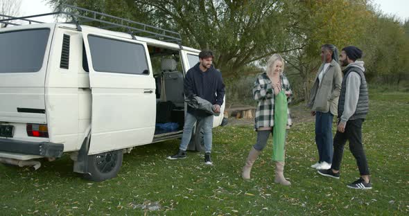 Four Friends Near a Camper Van By the River