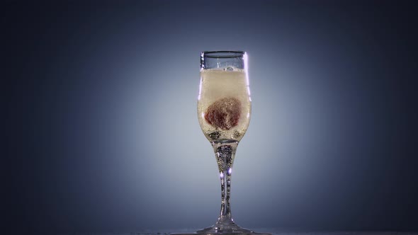 Slow Motion, in Glass with Champagne Wine Falling Fresh Strawberry