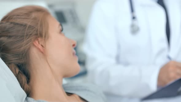 Doctor and Nurse Discussing with Young Woman Patient in Hospital