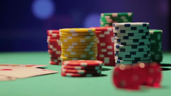 Rack Focus Shot of Pile of Poker Chips and Dice on Table, Casino Background
