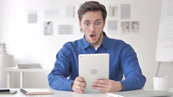 Casual Adult Man in Shock while Using Tablet