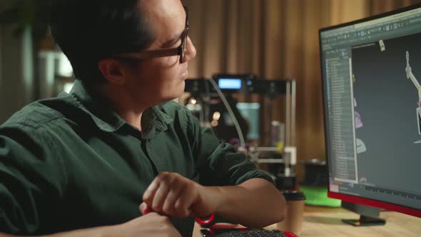 Asian Engineer Stretching While Work On Personal Computer And 3D Printer, Screen Shows 3d Drone