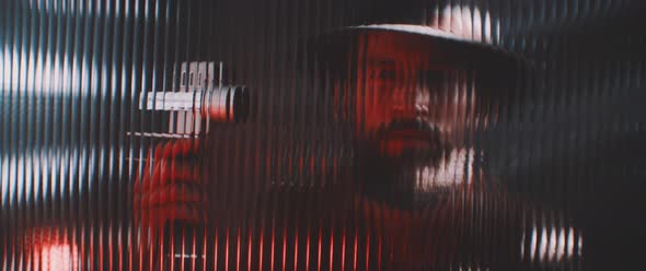 Shape of a man with camera thorugh shaped clear panel in red lights