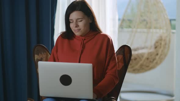 Tired brunette freelancer woman working in home office typing letter closing a computer