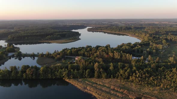 Sunset flight over a lake and a forest in Masuria (Mazury) region in Poland