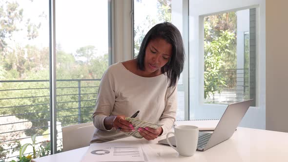 Mixed ethnicity woman working from home on her laptop