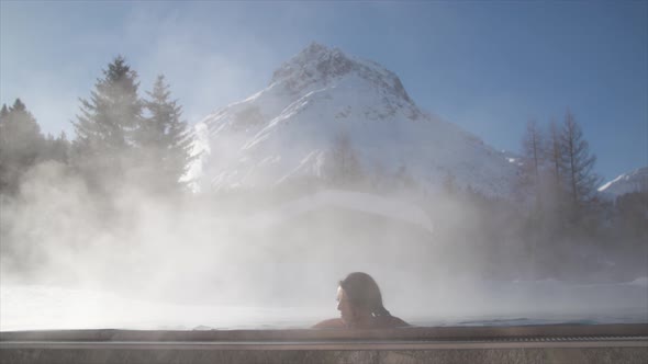 A woman relaxes in a hot tub jacuzzi at a spa.