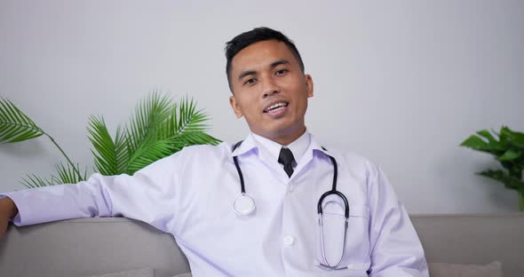 Doctor talking to patient making video call and looking at camera