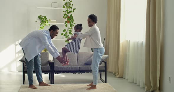 Young Parents Play with Their Daughter Together at Home Mom Dad and Little Girl Have Fun in Living Room