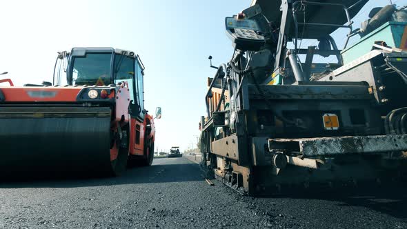 Fresh Asphalt Road with Paving Machines in a Front View