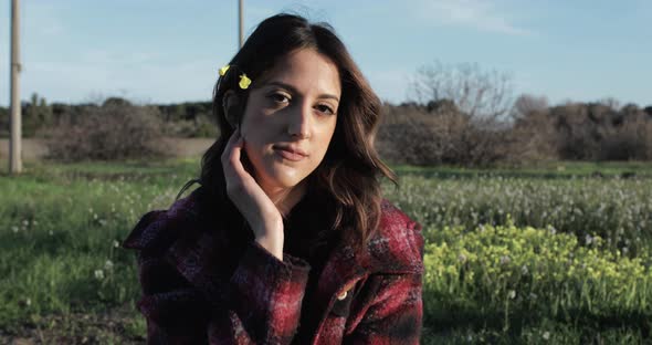 girl smiles with a yellow flower in her long hair