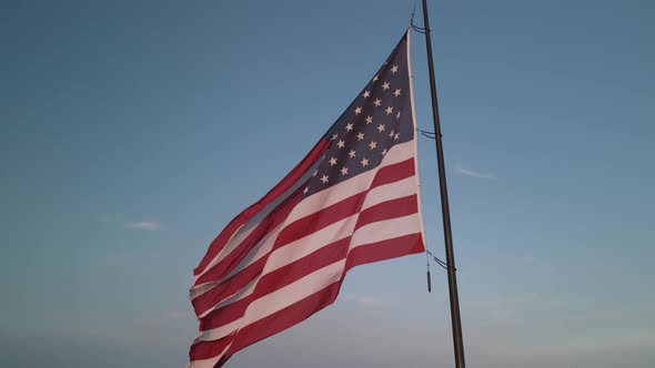 The American Flag Fluttering in the Wind at Sunset