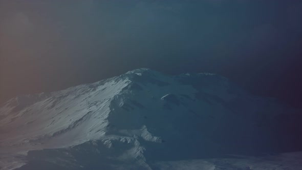 Dramatic Dark Rocky Mountain with Patches of Snow in Storm