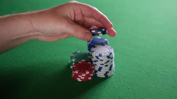 Impatient man playing with poker chips in casino