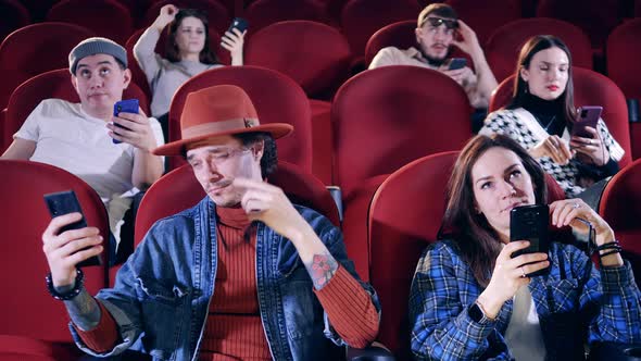 Bored Viewers are on Their Phones at the Cinema