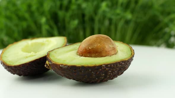 Avocado rotates on a green grass background. 4K video close-up of wholesome and healthy food