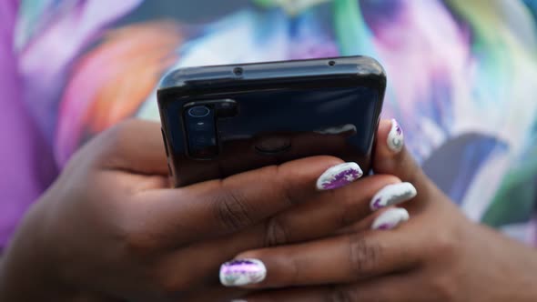 Close-up of Black Phone in Hands of African Woman